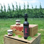 two bottles of Asian Pear vinegar on a crate with pear trees in background